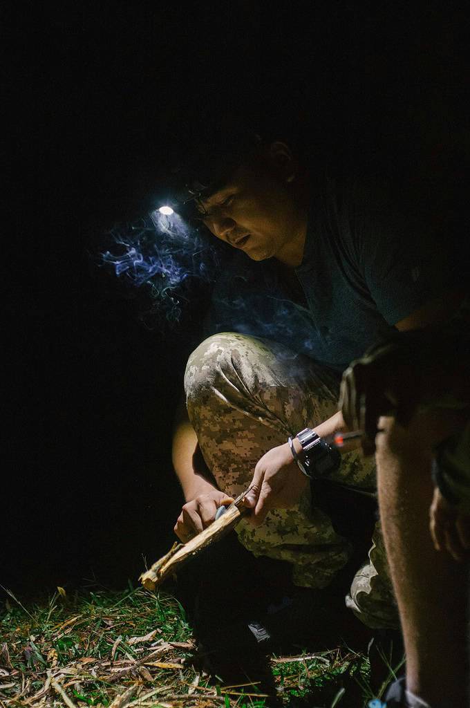a man starting a fire outdoor at nighttime