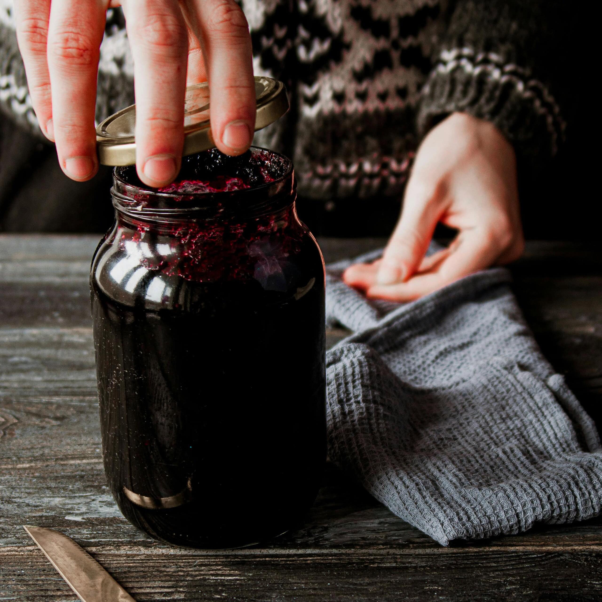 Hand Closing Jar of Blackberry Jam