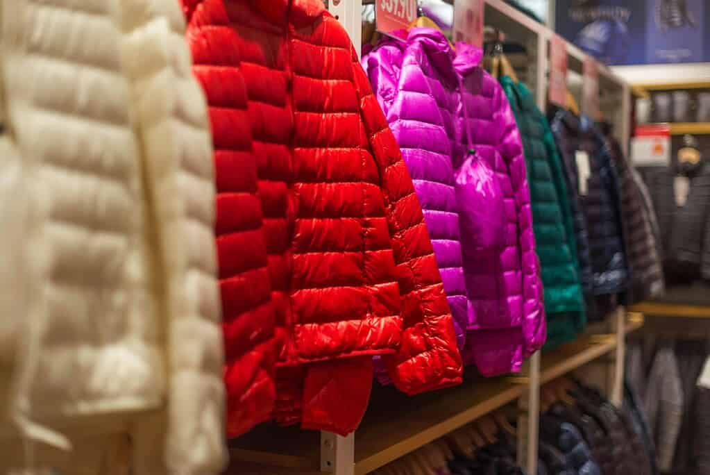 Assorted winter coats neatly hung in a row