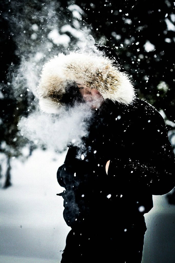 Man wearing a thick winter jacket outdoors in snowy weather