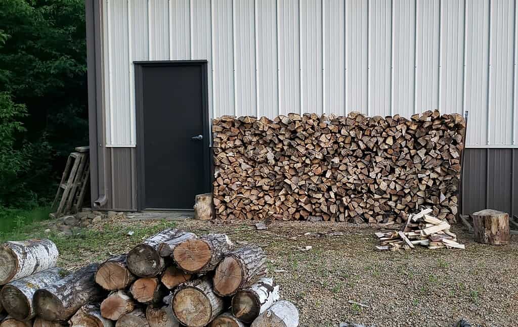 Woodpile stacked by a barn