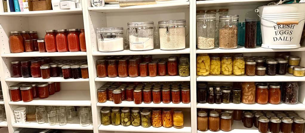 a beautifully organized pantry filled with home-canned and preserved foods