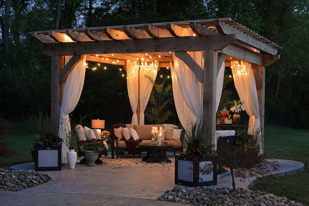 a cozy, upscale wooden pergola with ambient lighting