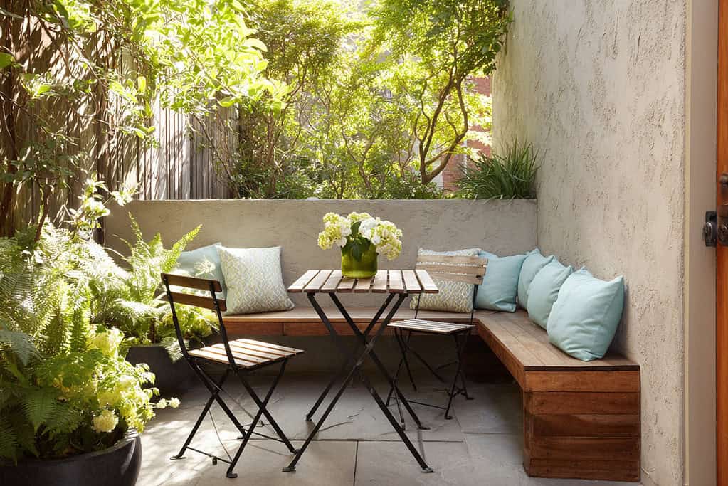 a small courtyard garden furnished with compact, space-saving furniture that blends comfort with function