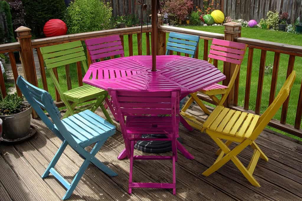 a colorful wooden patio furniture set arranged on a wooden deck