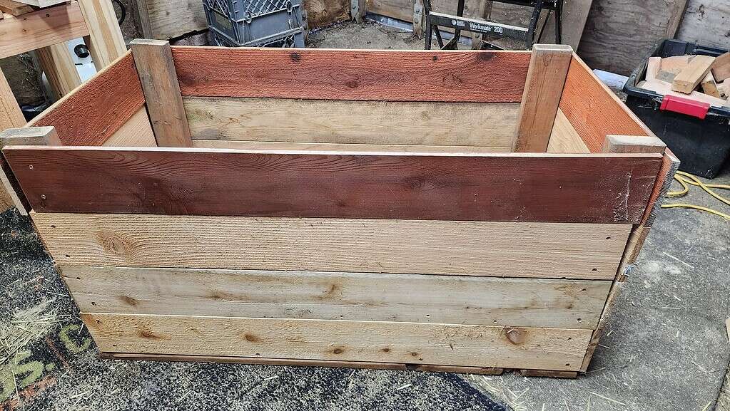 a handcrafted wooden planter box constructed from reclaimed and mixed-tone lumber.