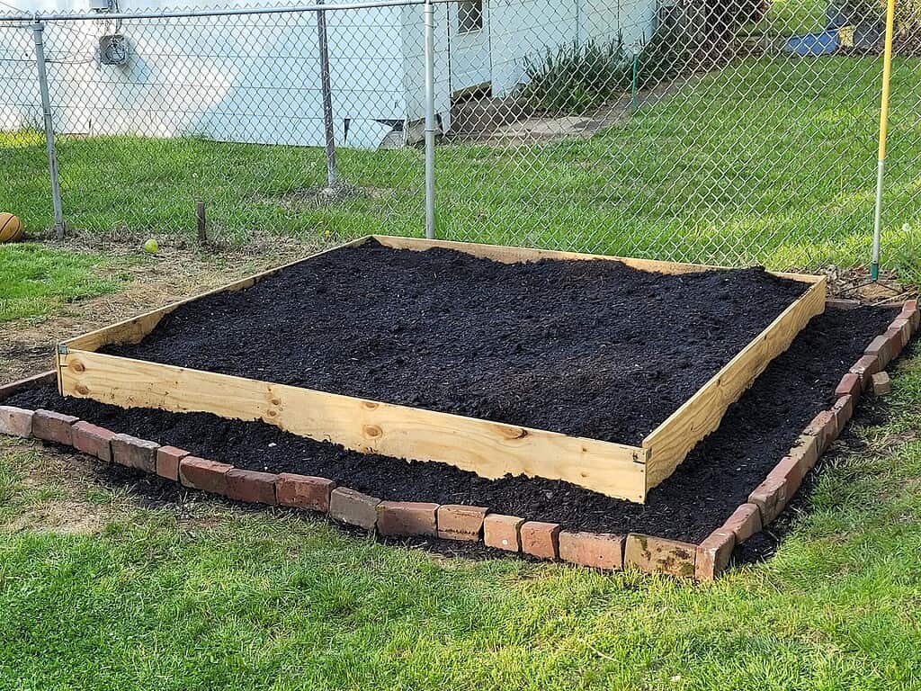 a freshly constructed backyard raised garden bed, ready for planting