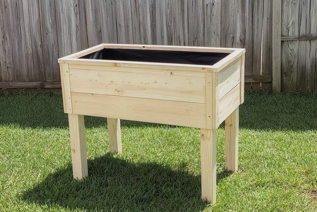 a handcrafted elevated planter box made from fresh, light-colored pine wood.