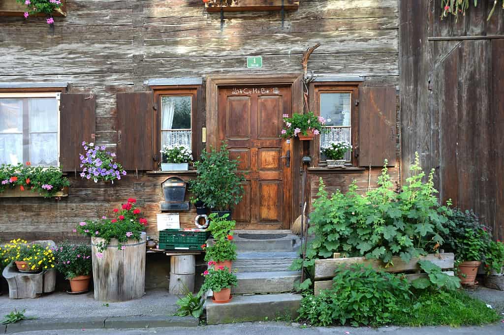 a charming rustic wooden cottage entrance in a European alpine village.