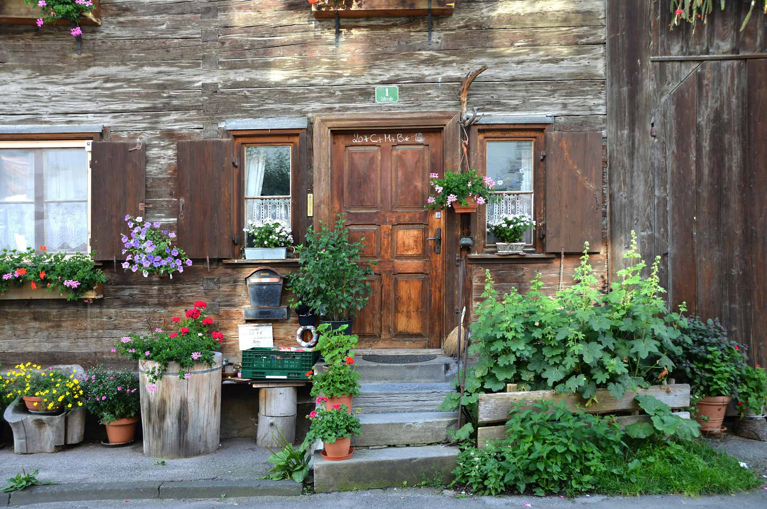 a charming rustic wooden cottage entrance in a European alpine village.