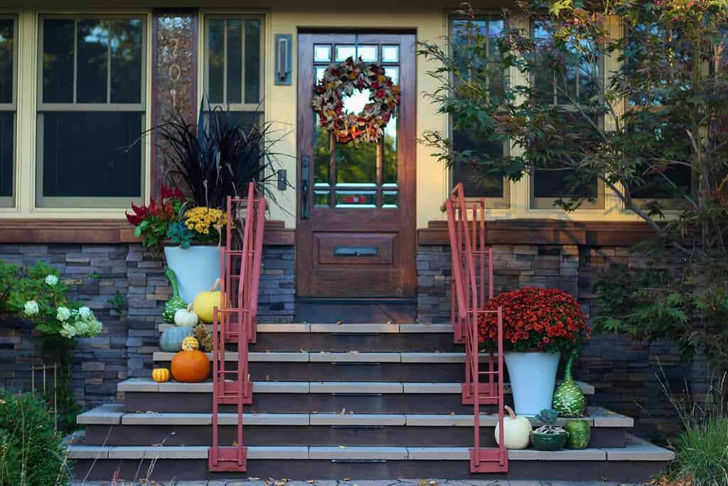 a beautifully styled suburban front porch decorated for autumn