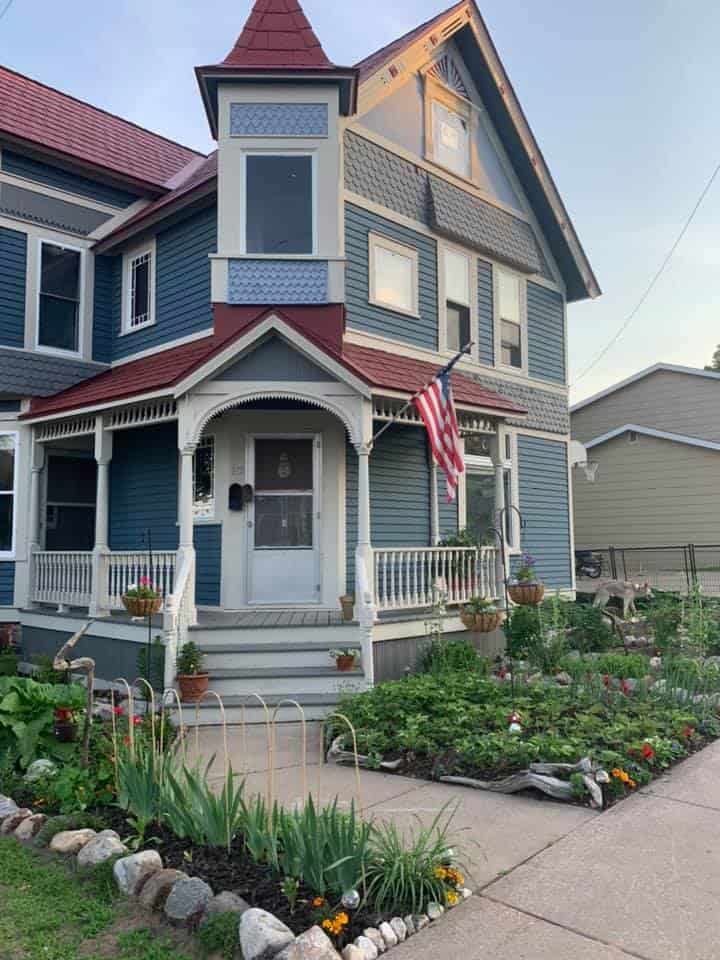 front yard garden beds with stone edging along walkway