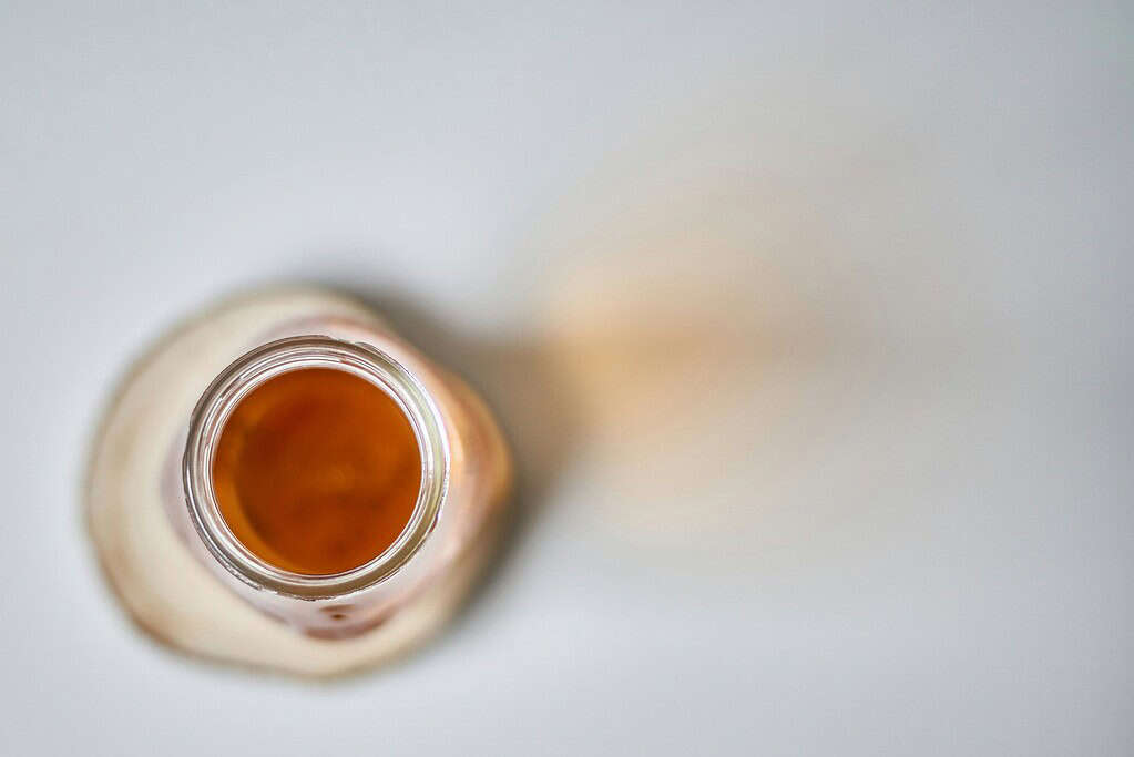 Top view of an open bottle with an apple cider vinegar inside.