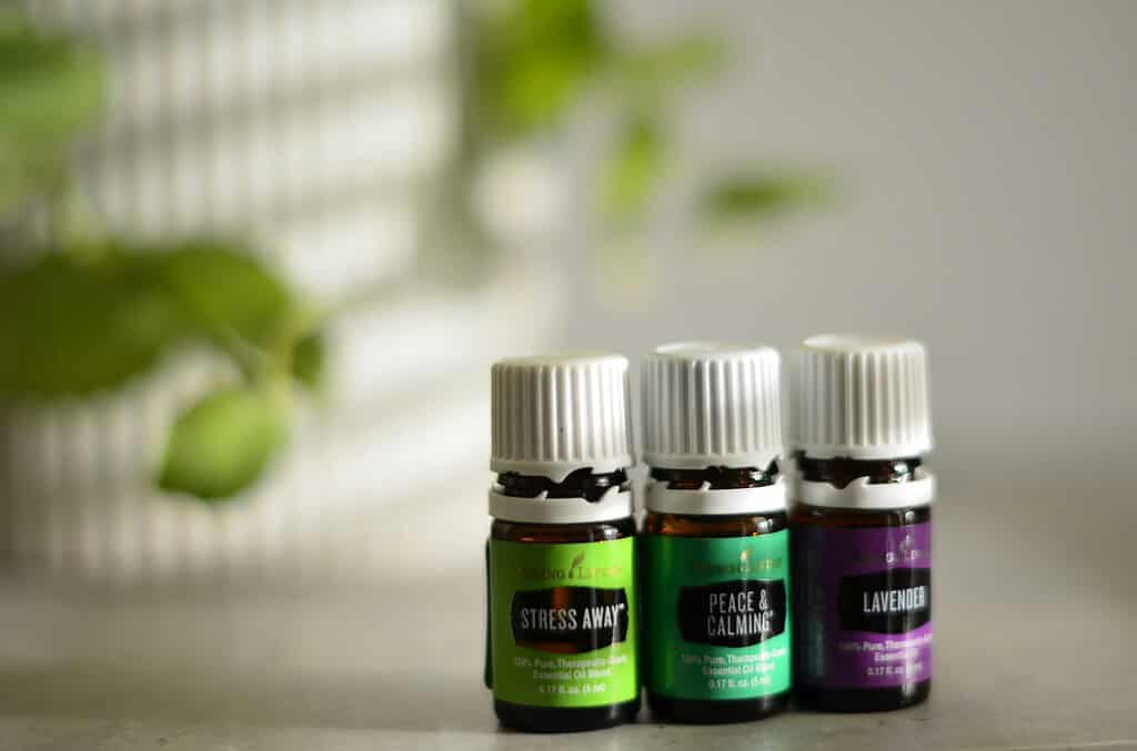 Three small bottles of essential oils labeled “Stress Away,” “Peace & Calming,” and “Lavender.”