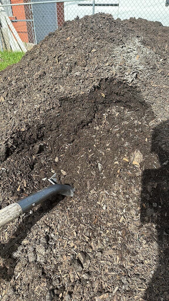 compost pile with shovel and rich organic soil ready for garden use