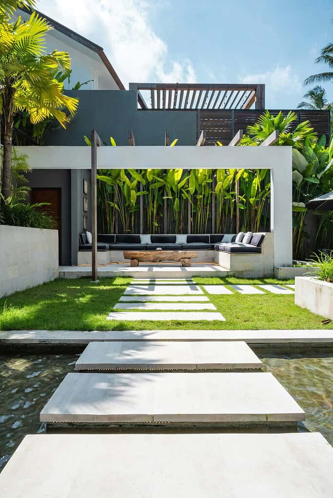 Above ground pool backyard with modern patio seating and tropical landscaping