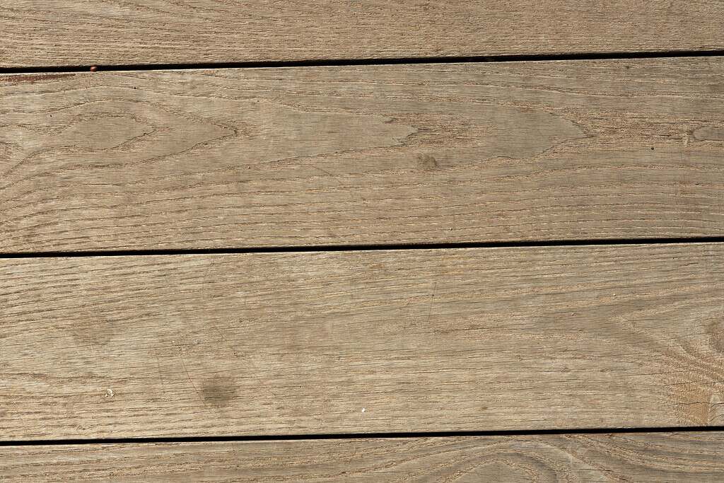 Wooden pavers with visible grain and narrow gaps between planks.
